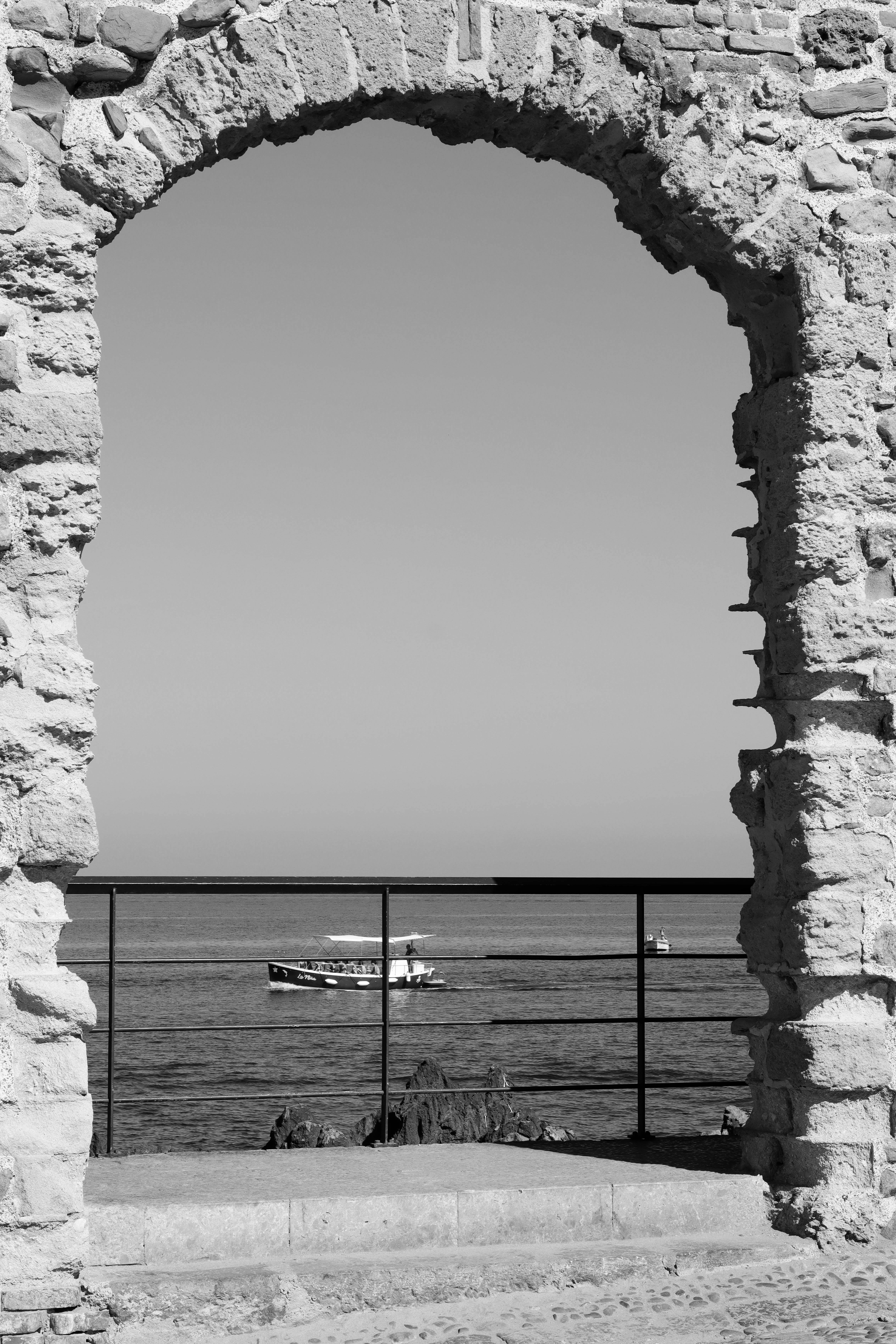 View through a stone archway to the sea